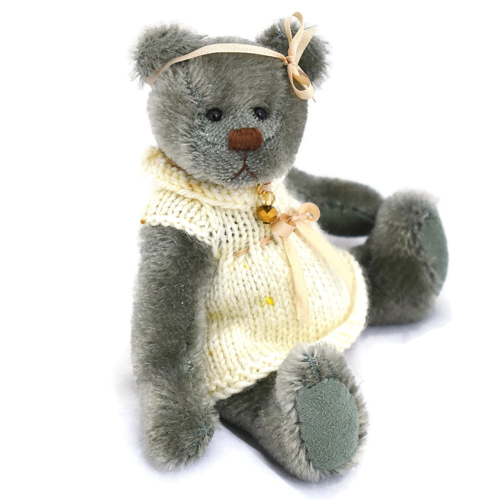 Handmade fully jointed miniature teddy bear dressed in pale lemon handknitted dress